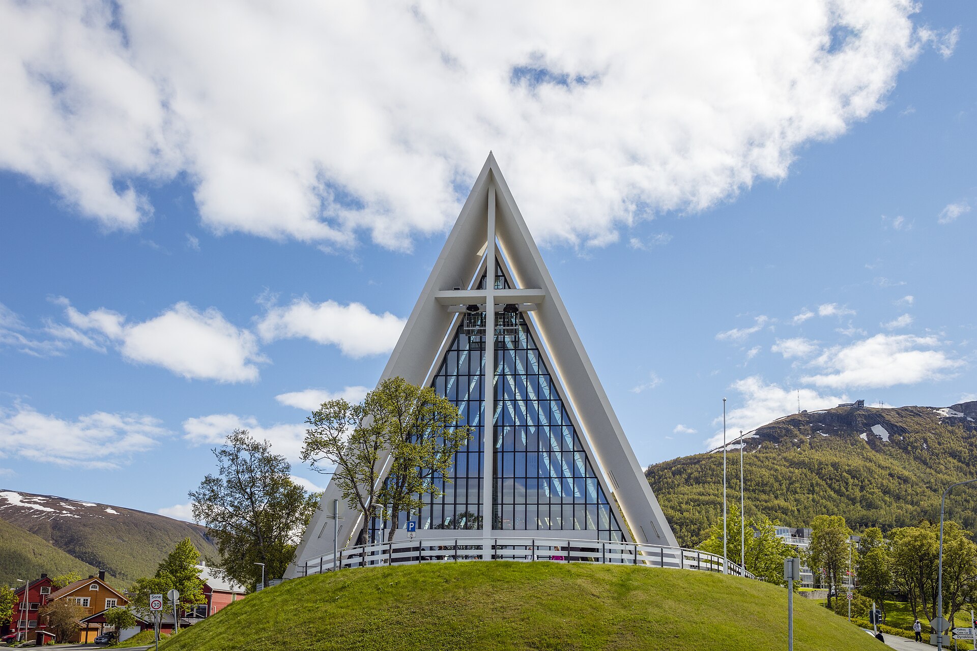 Ishavskatedralen i Tromsø mot blå himmel med snø på fjellene